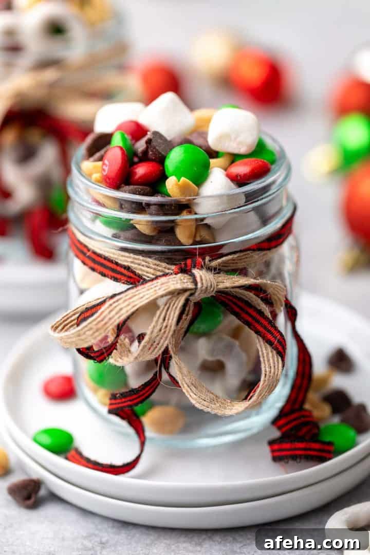 Christmas Trail Mix: Sweet and Salty Holiday Snack Recipe 6 Close up view of a jar of snack mix with ribbons.