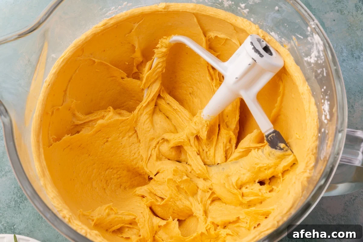 Mixed pumpkin focaccia dough in a stand mixer bowl with paddle attachment.