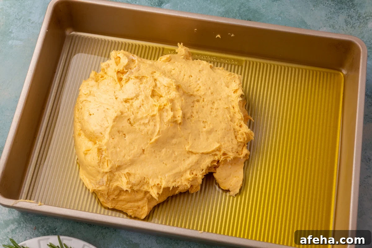 Pumpkin focaccia dough placed in an oiled baking pan before spreading.
