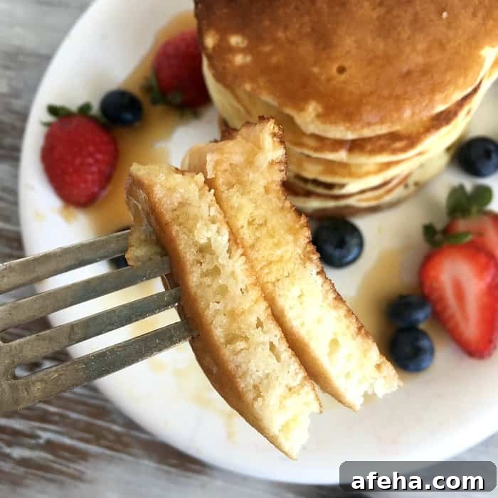 Fork with piece of buttermilk pancakes.