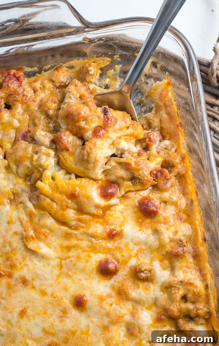 low carb taco casserole in a baking dish, seen from above. a spoon pokes out from the dish.