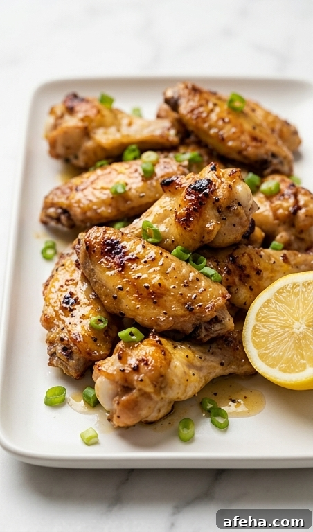 Plated lemon pepper wings garnished with green onion
