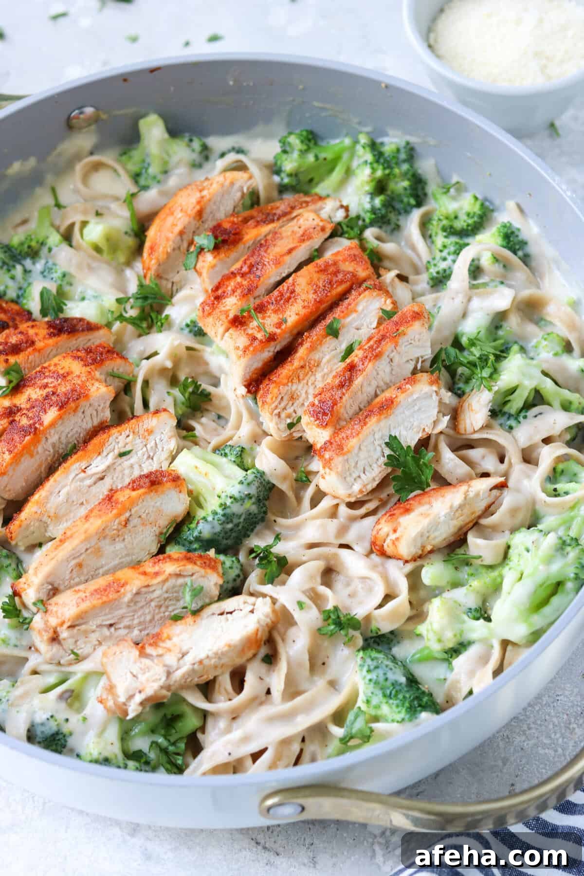 chicken and broccoli with alfredo sauce and gluten free tagliatelle pasta in a skillet