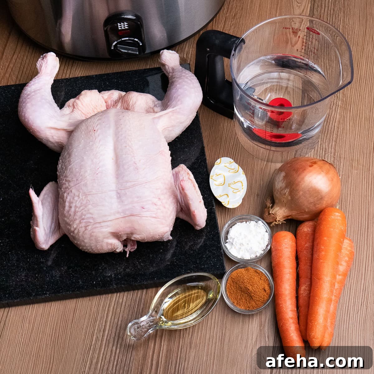 A whole raw chicken, four carrots, olive oil, all purpose seasoning, cornflour, chicken stock cube, one onion, a jug of water and a slow cooker