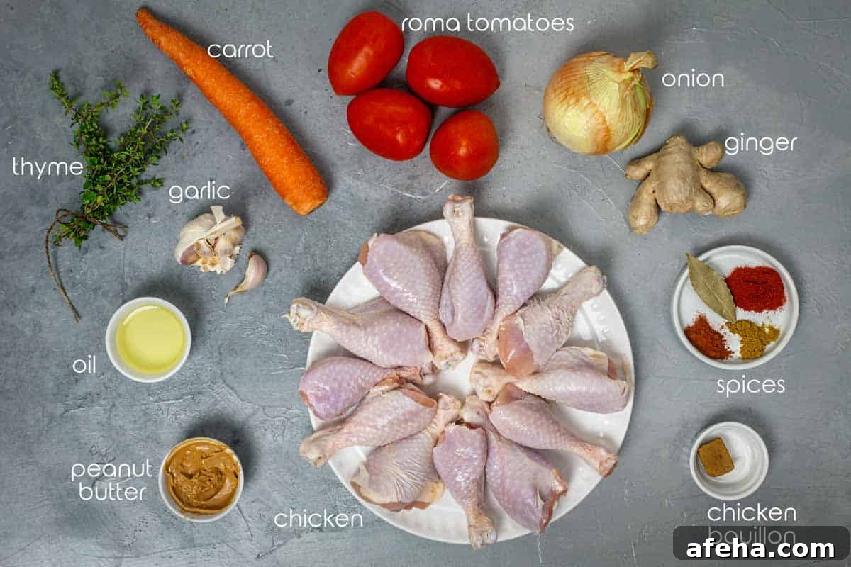Ingredients for West African groundnut stew with chicken drumsticks, tomatoes, ginger, carrot, garlic, and onion.
