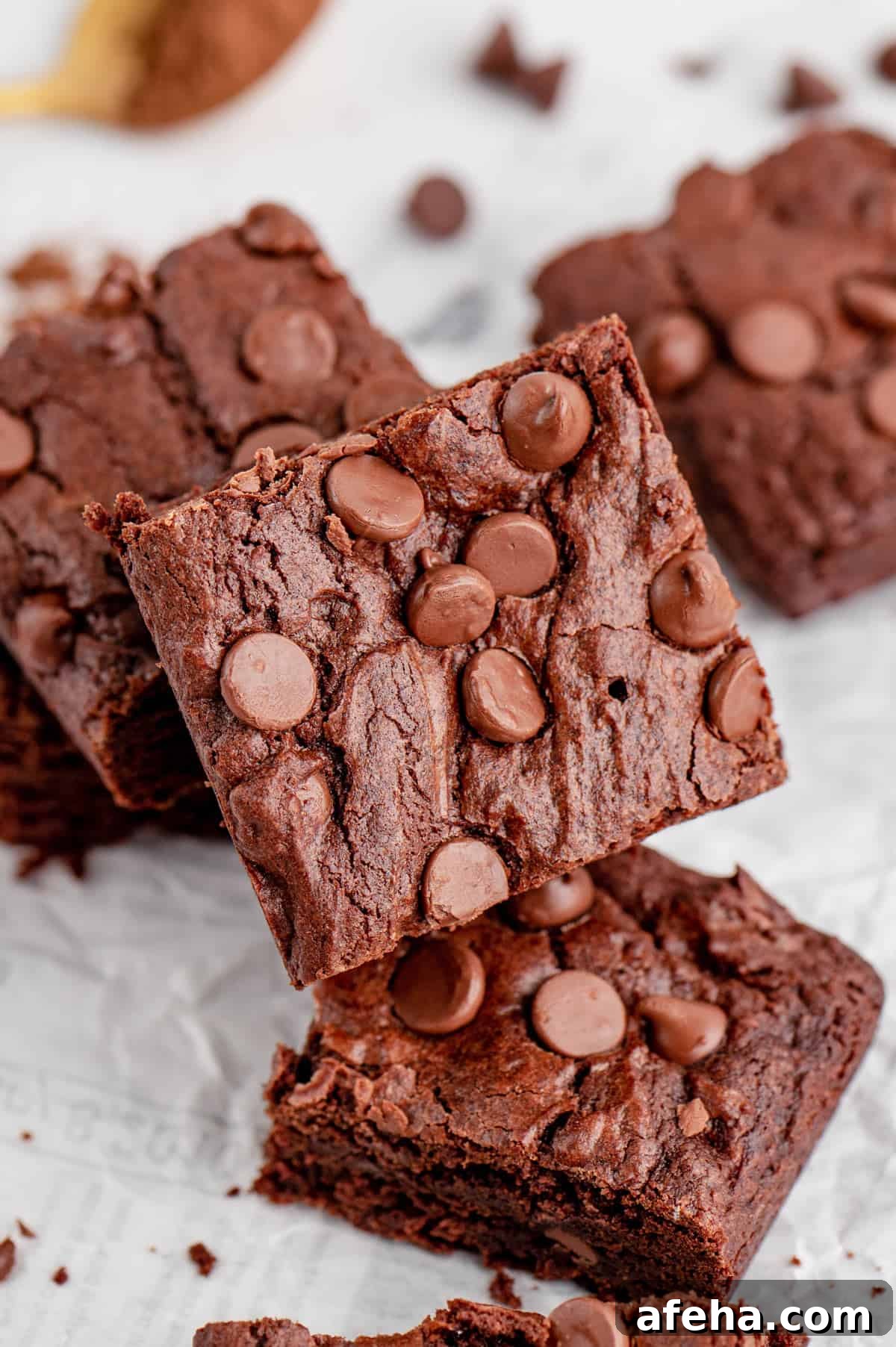 Close up of a piece of air fryer brownie propped on top of more pieces.