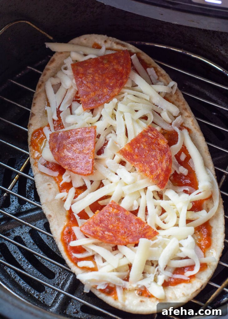 Placing pita pizza into air fryer basket
