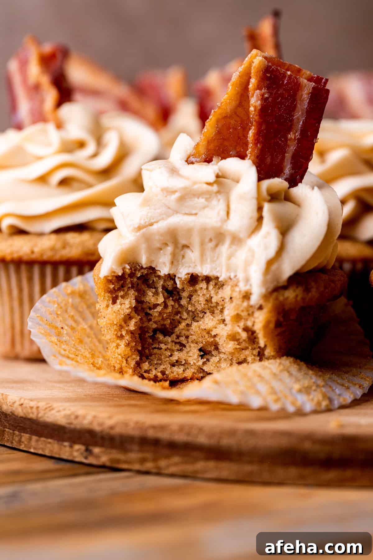 Close up of a bite missing from maple bacon cupcakes.