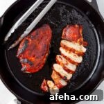 Barbecue chicken breasts in a cast iron skillet.
