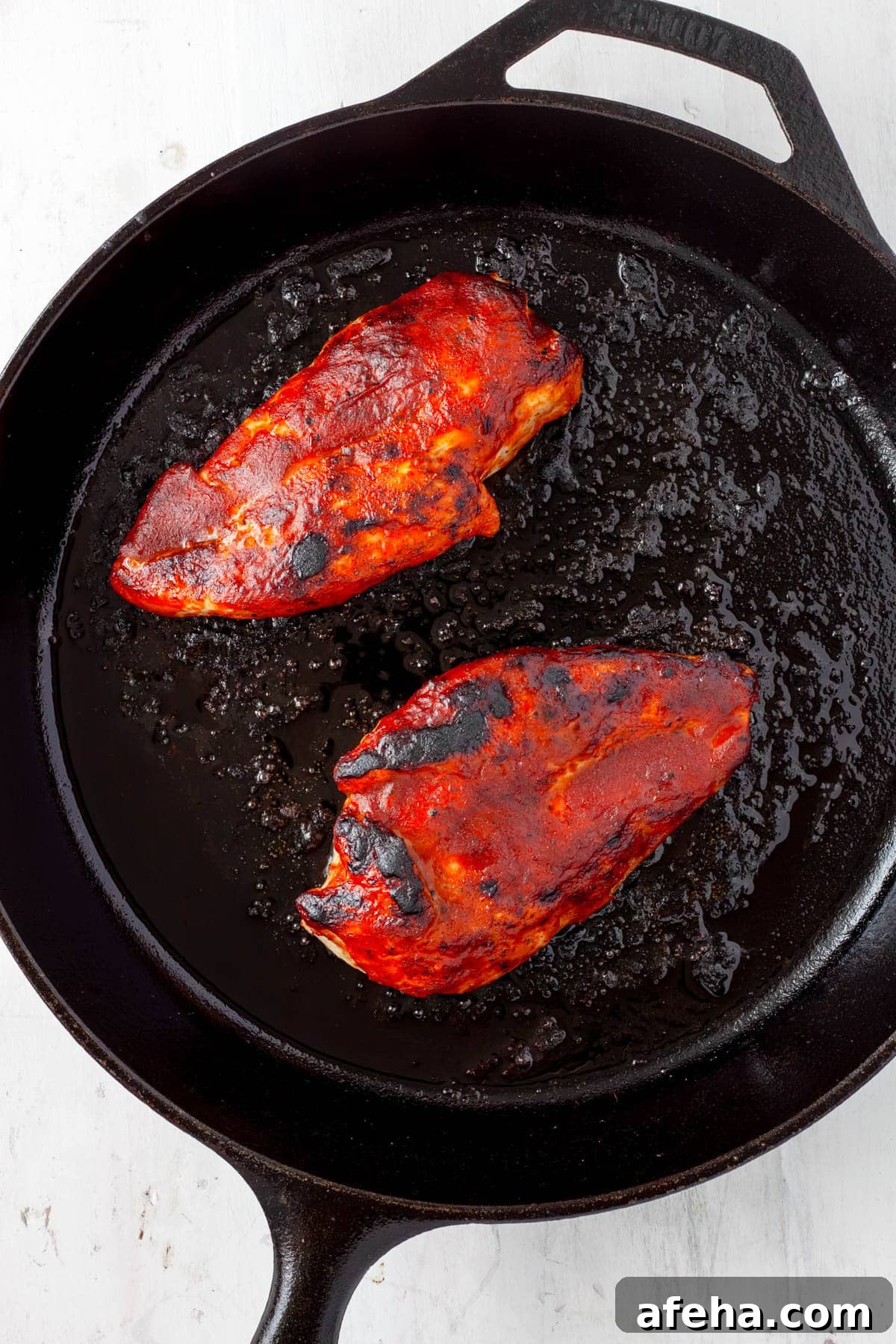 Cast Iron BBQ Chicken Breast Recipe 7 BBQ cast iron skillet chicken charred and brushed with more sauce.