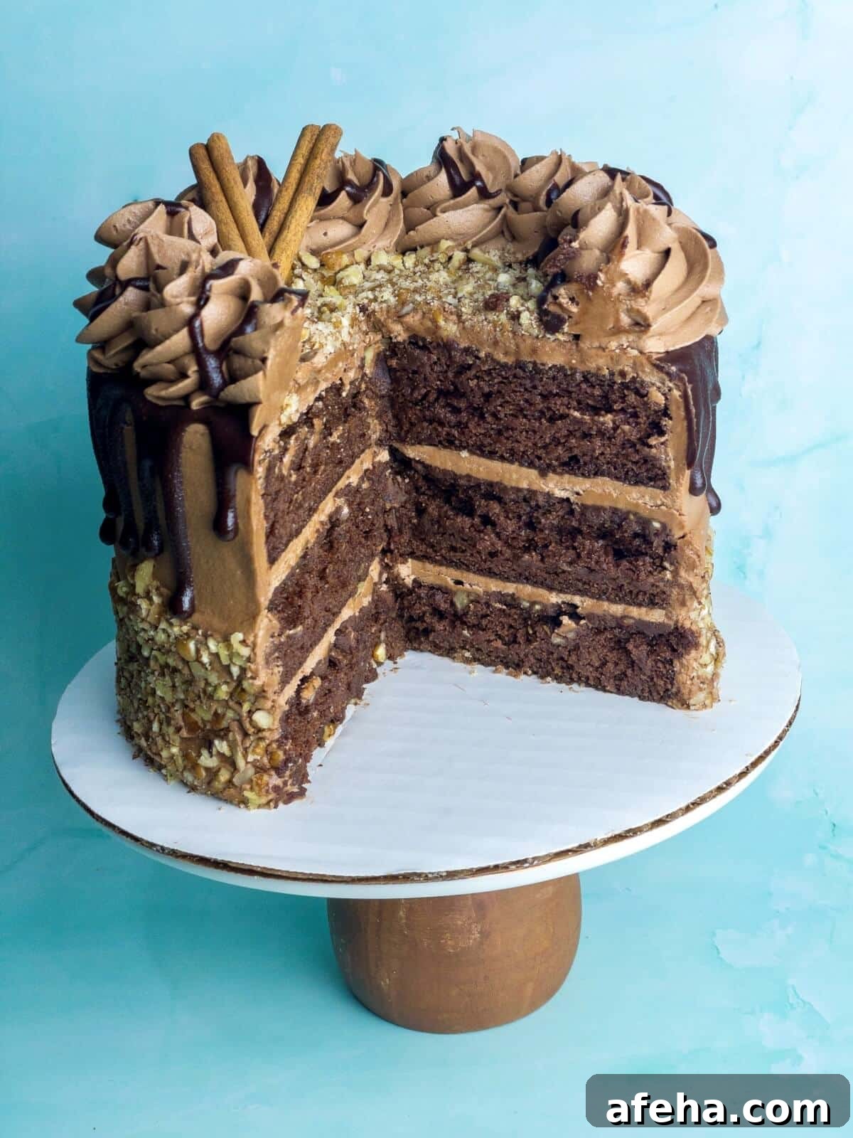 chocolate cinnamon layer cake on a stand with slices missing